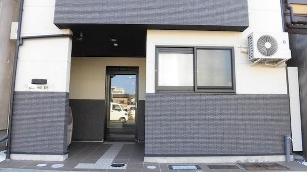Stylish entrance with a glass door and contrasting brickwork.