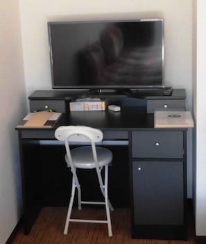 Work in comfort with a compact desk and flat-screen TV.
