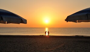 Privatstrand, Liegestühle, Sonnenschirme, Volleyball