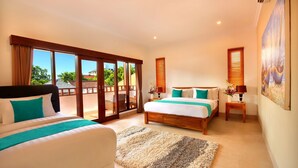 A hotel room with a large bed, a smaller bed, a balcony with glass doors, and a painting on the wall. - Villa De Liza Seminyak Beachside (Seminyak)