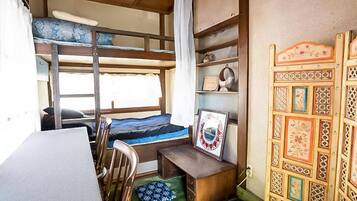 A bunk bed room with a desk and shelves, a framed picture, and a decorative wall panel.