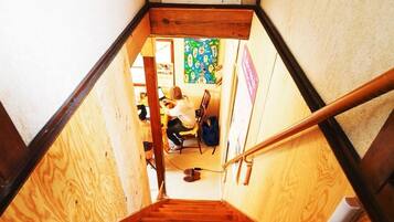 A wooden staircase leading to a room with a colorful heart-shaped artwork on the wall.