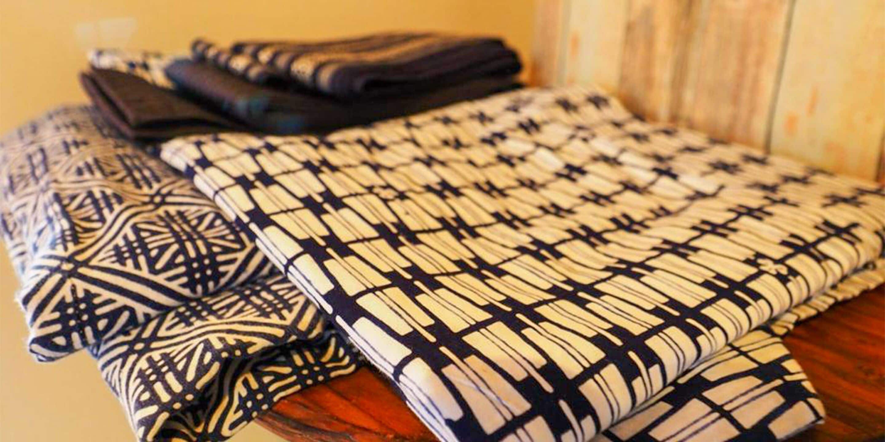A neatly folded bed with a patterned bedspread.