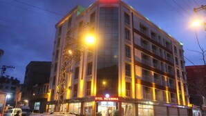 Un hotel de varios pisos con un letrero llamativo que dice 'OTEL RESMNA' en la parte superior.