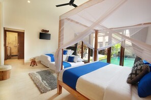 A bedroom with a canopy bed, a second bed, a TV, and a view of a swimming pool. - Concetta Villa Seminyak Beachside (Seminyak)