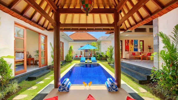 A poolside area with a covered seating area, a pool, and a view of the house. - Nicola Villa Seminyak Beachside (Seminyak)