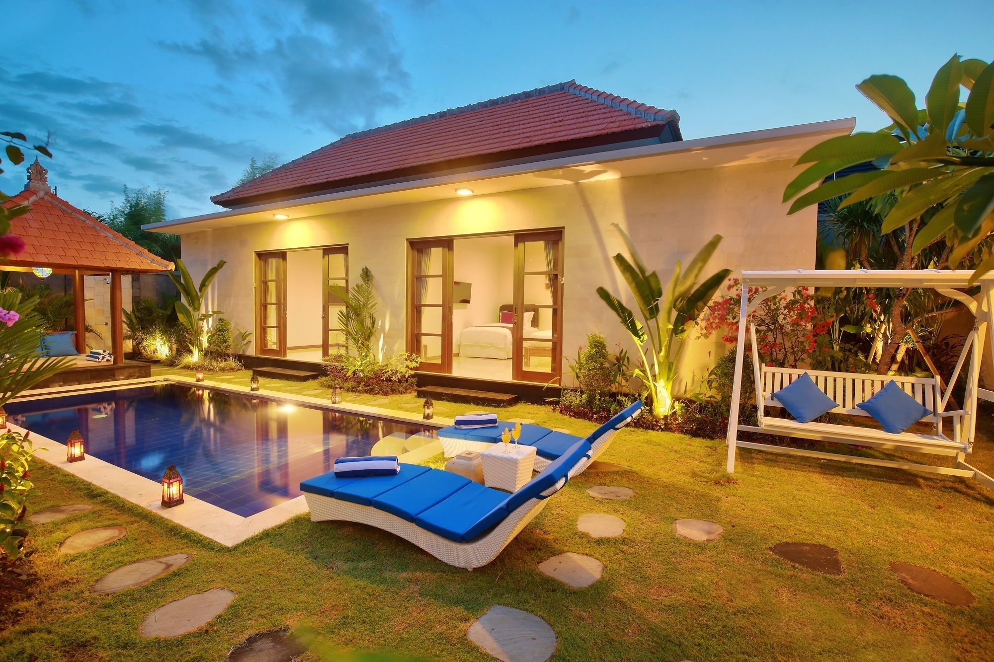 A modern house with a swimming pool, a covered patio, and a garden.