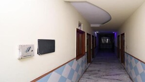 Um corredor com um padrão de piso xadrez, teto curvo e uma porta no final.