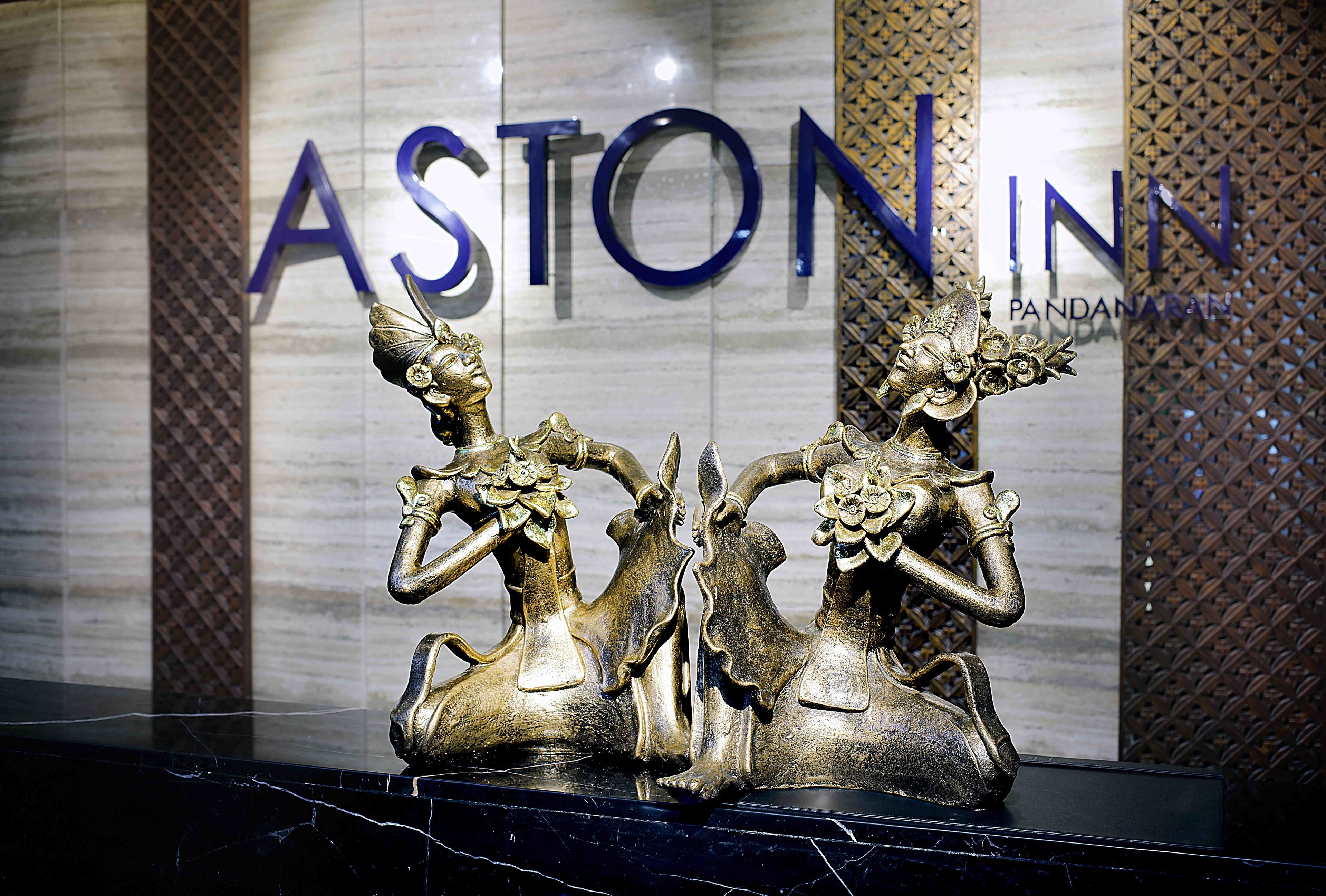 En guldfärgad staty som föreställer en kvinna och en häst, placerad framför en skylt för Aston Inn.