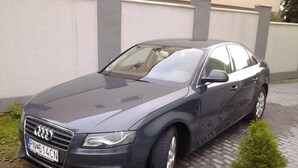 Un automóvil Audi de color oscuro estacionado en un camino de entrada pavimentado.