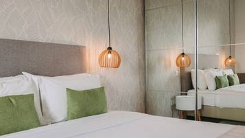 A modern hotel room with a large bed, green pillows, and a textured wall.