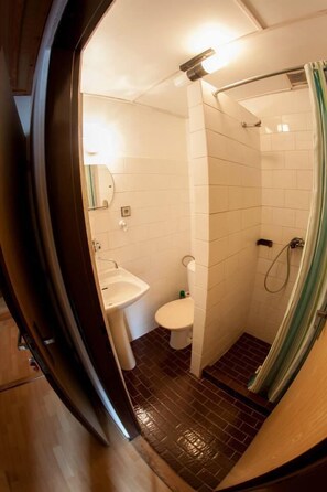 A compact bathroom with a sink, toilet, and shower. - Penzion Mona (Bela pod Pradedem)