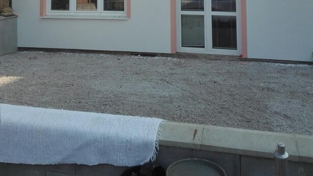 A single-story building with a flat roof, two windows with pink frames, and a sliding glass door. - Apartmany Halex 4 (Bojná)