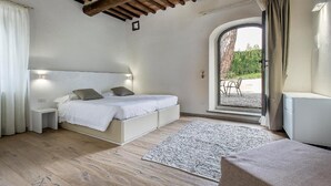 A bedroom with a bed, bedside tables, a rug, and a view of the outdoors. - Salvadonica - Borgo del Chianti (San Casciano in Val di Pesa)