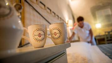 Duas chávenas de café com a marca 'Salvadonica' sobre uma mesa num quarto de hotel.