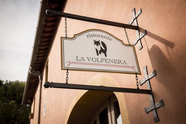 Un letrero de restaurante con un logotipo de gato y el nombre "LA VOLPENERA".