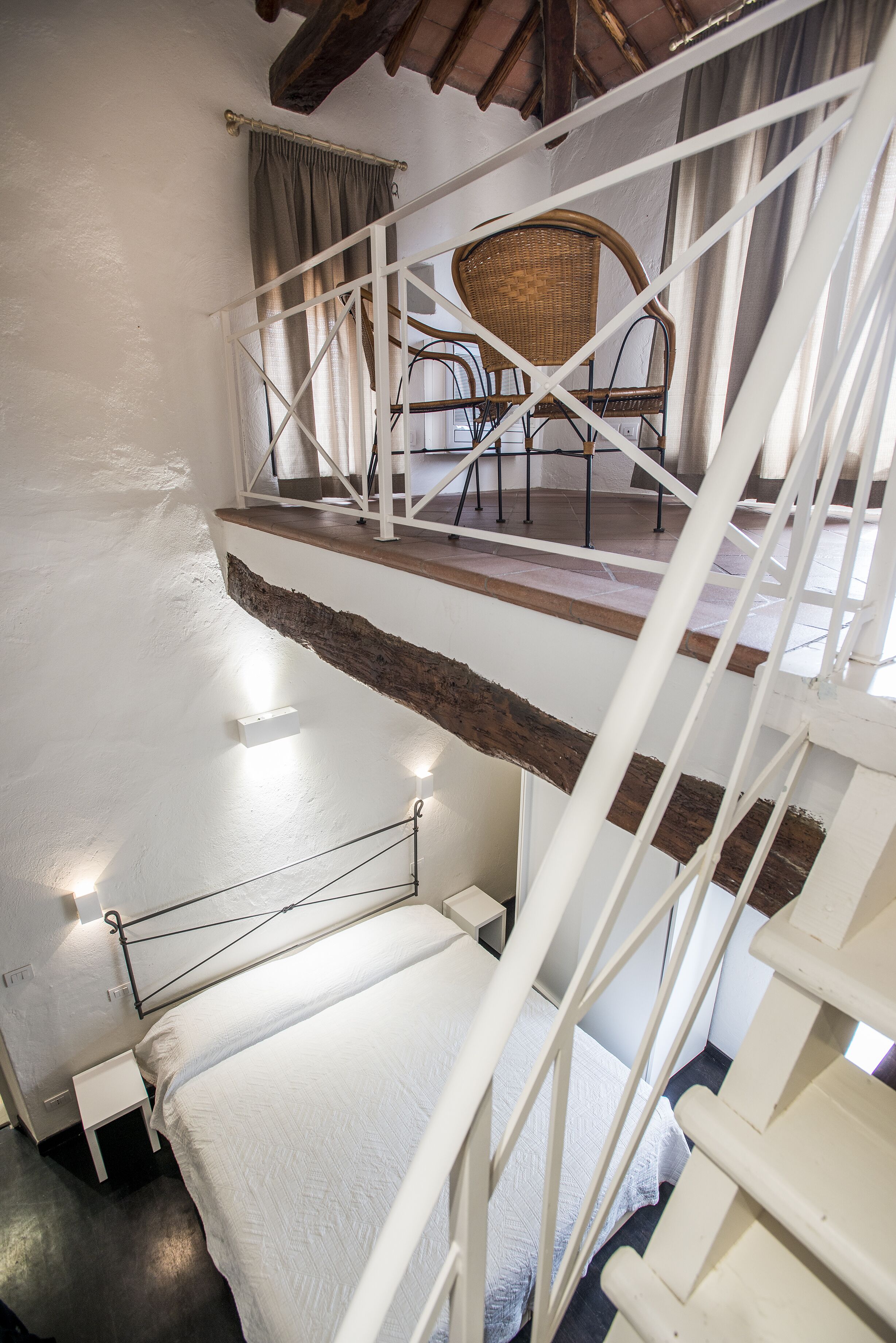 A staircase with a white railing leading to a second-floor balcony.