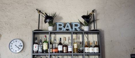 A bar area with a clock and shelves of liquor bottles.