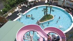 Una piscina con dos toboganes y una pequeña isla.