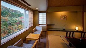 Una habitación japonesa tradicional con suelo de tatami, una mesa baja y un banco.