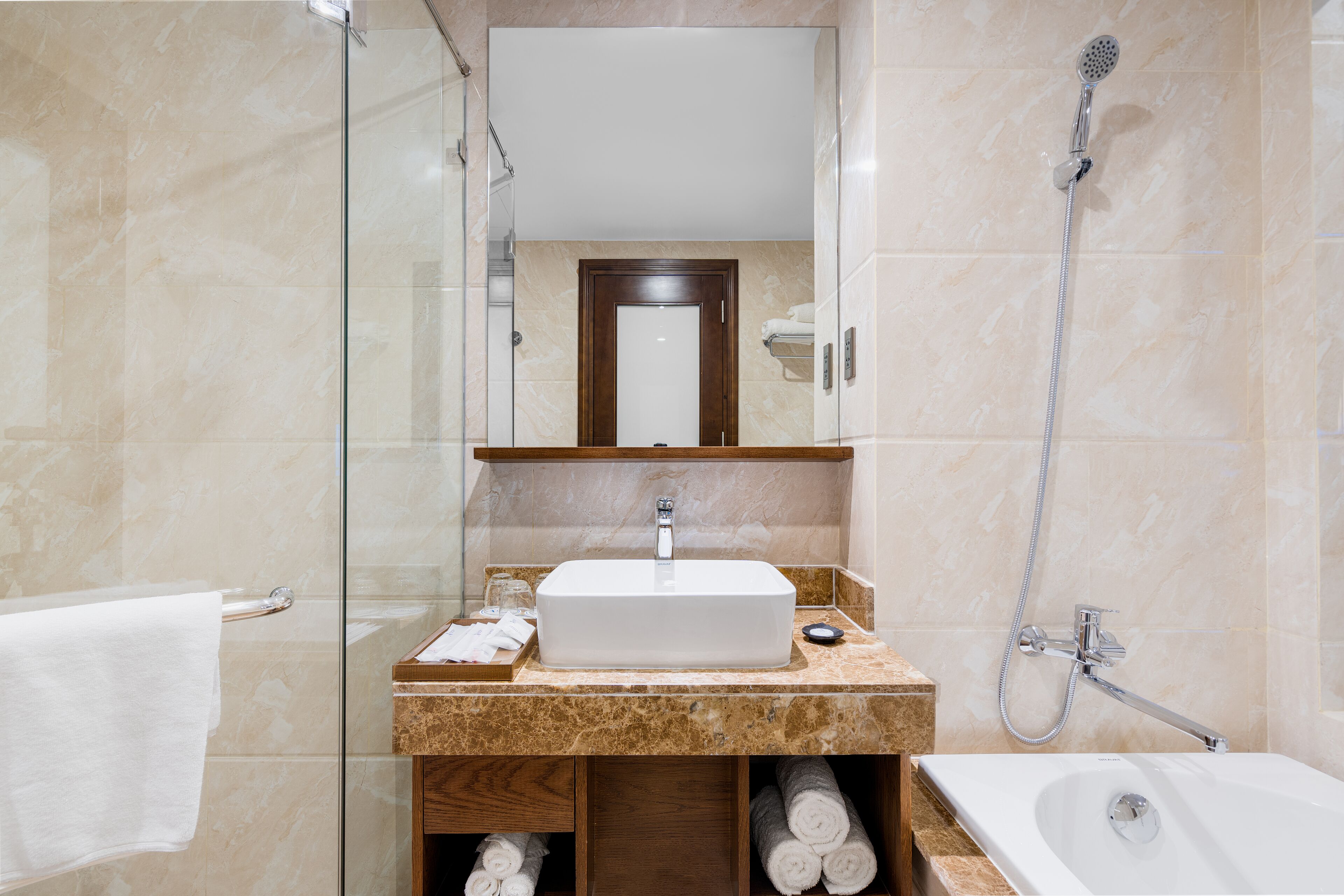 Ein modernes Badezimmer mit einer Duschkabine aus Glas, einem weißen Waschbecken und einer separaten Badewanne.