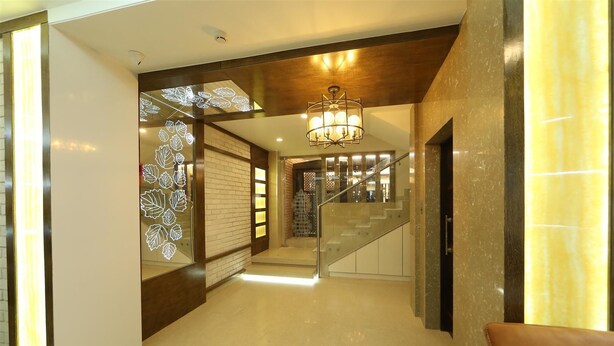 Un interior moderno con una escalera, una araña y un diseño de pared con motivos.