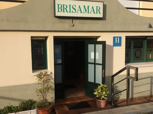 A building with a sign reading "BRISAMAR" and a staircase leading to an entrance. - Hotel Brisamar (Gozon)