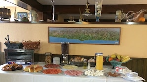 A buffet table with various food items and a painting on the wall. - Hotel Brisamar (Gozon)