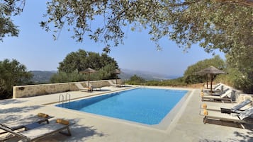 Piscine extérieure, parasols de plage, chaises longues