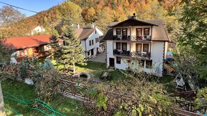 A two-story house with a balcony, surrounded by a garden and a forested hillside. - Abant Dort Mevsim Konagi (Bolu)