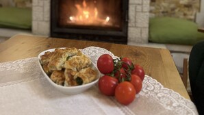 A table with a plate of food and tomatoes, a fireplace, and stone walls. - Abant Dort Mevsim Konagi (Bolu)