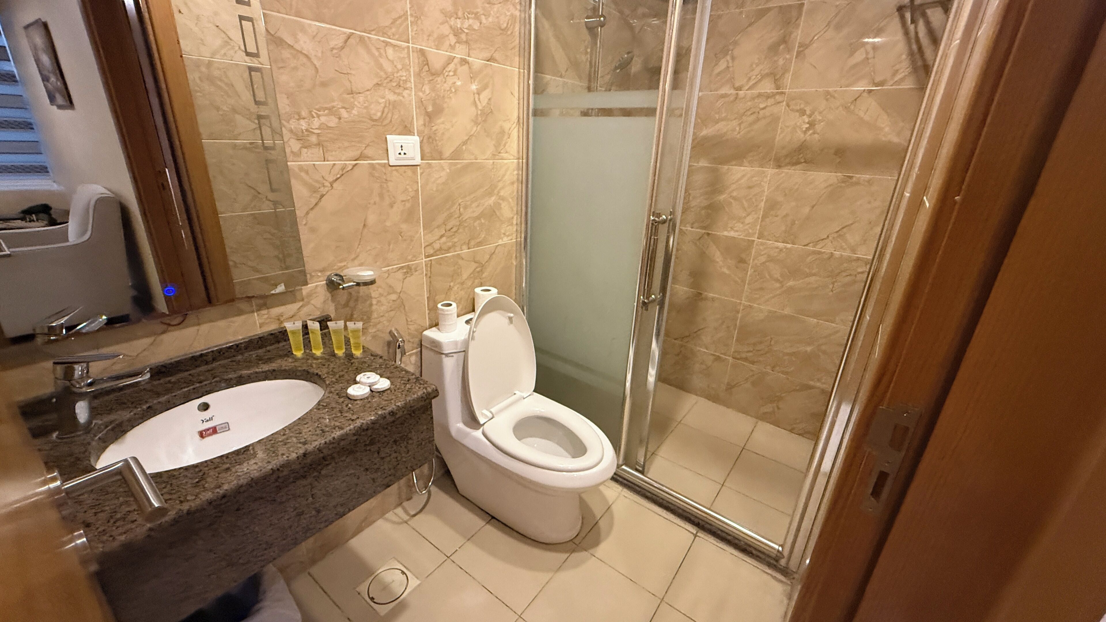 A bathroom with a sink, toilet, and glass shower enclosure.