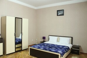 A bedroom with a bed, a wardrobe, a nightstand, and a wall-mounted picture. - Abu Turan Hotel (Baku)