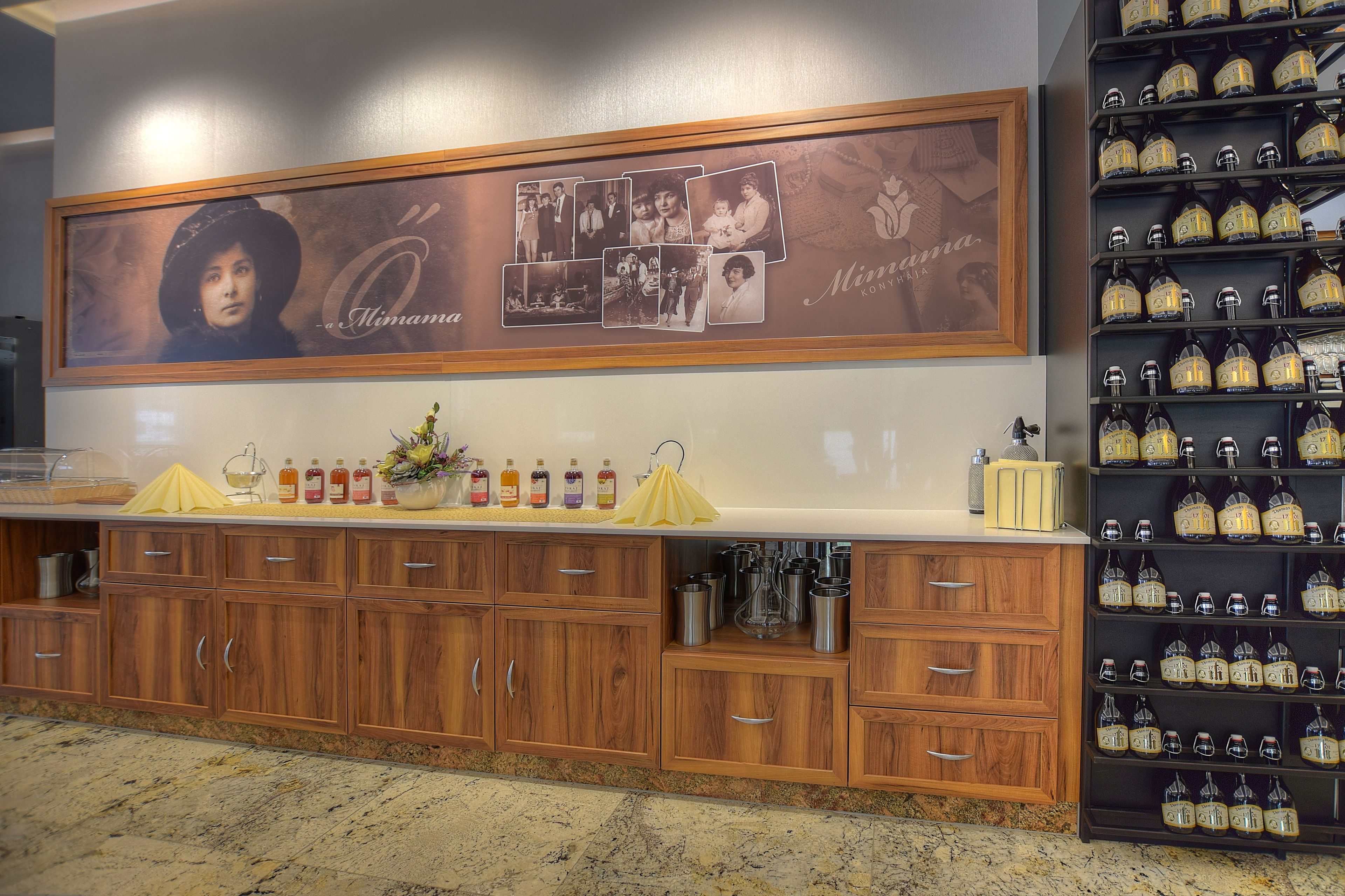 A kitchen area with wooden cabinets, a marble countertop, and a display of wine bottles.
