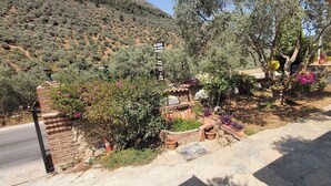 A landscaped area with a stone wall, potted plants, and a sign. - Sirince Klaseas Hotel & Restaurant (Selçuk)