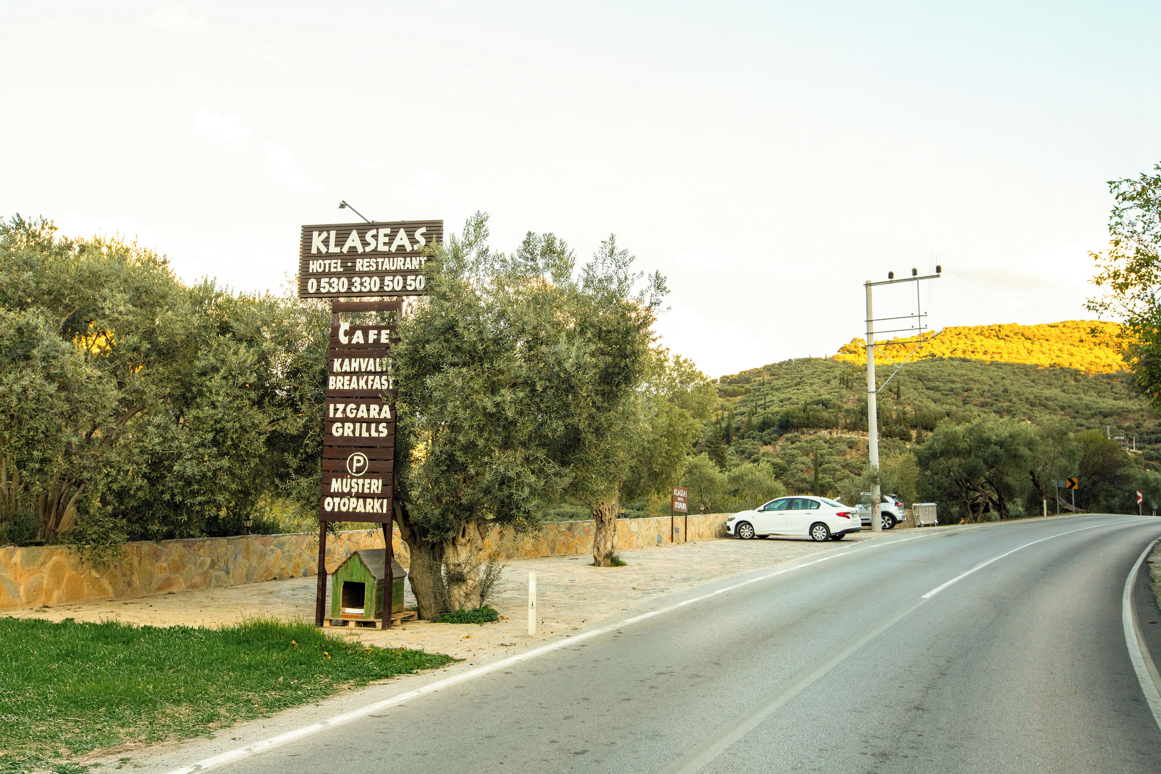 Señal de un hotel y restaurante llamado 'Klasas', con servicios como cafetería, desayuno y parrillas.