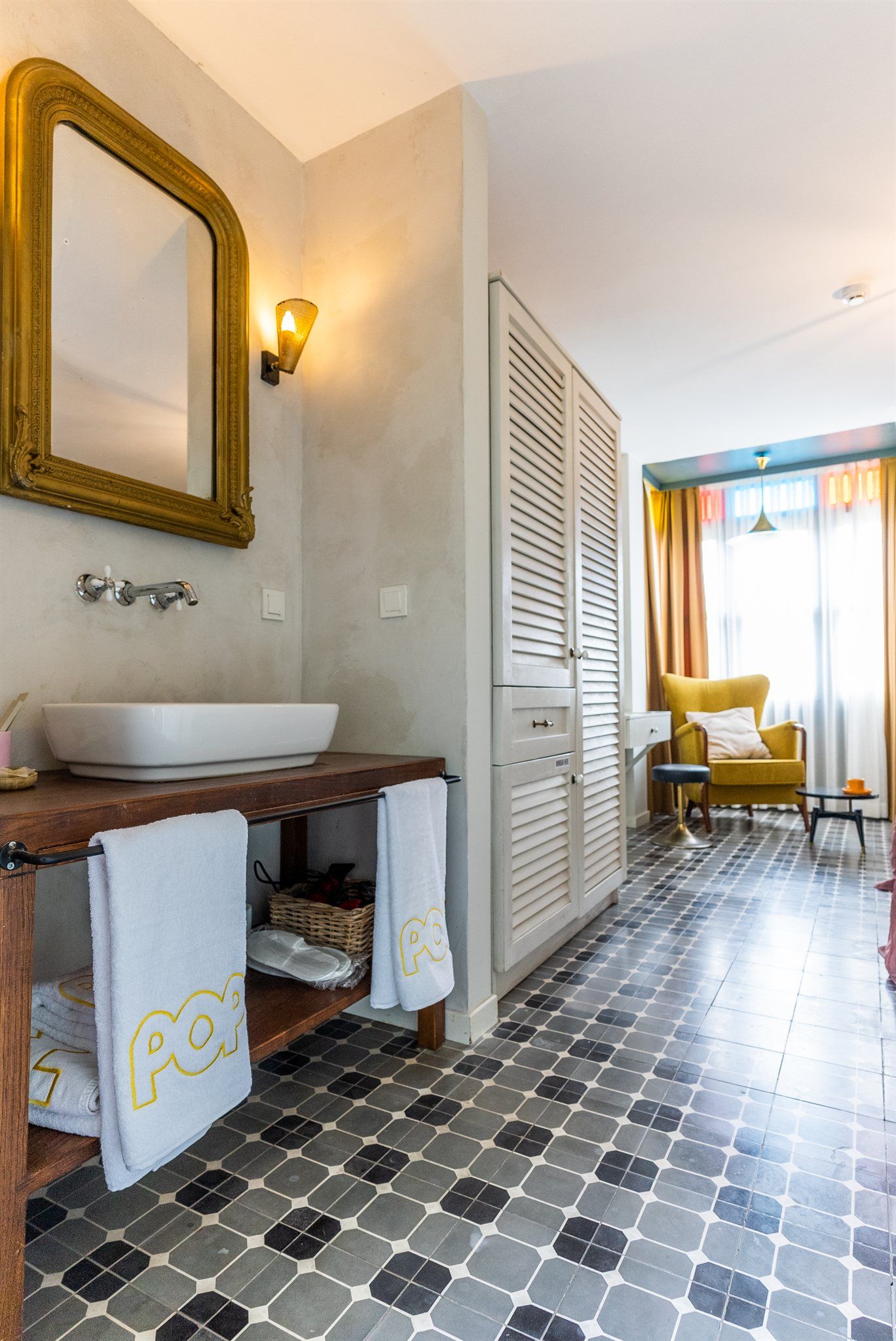 A bathroom with a large mirror, a sink, and a towel rack.