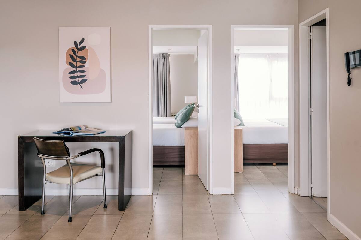 A modern room with a desk, chair, and a bed with a view.