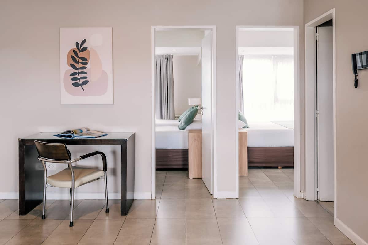 Una habitación moderna con escritorio, silla y cama con vistas.