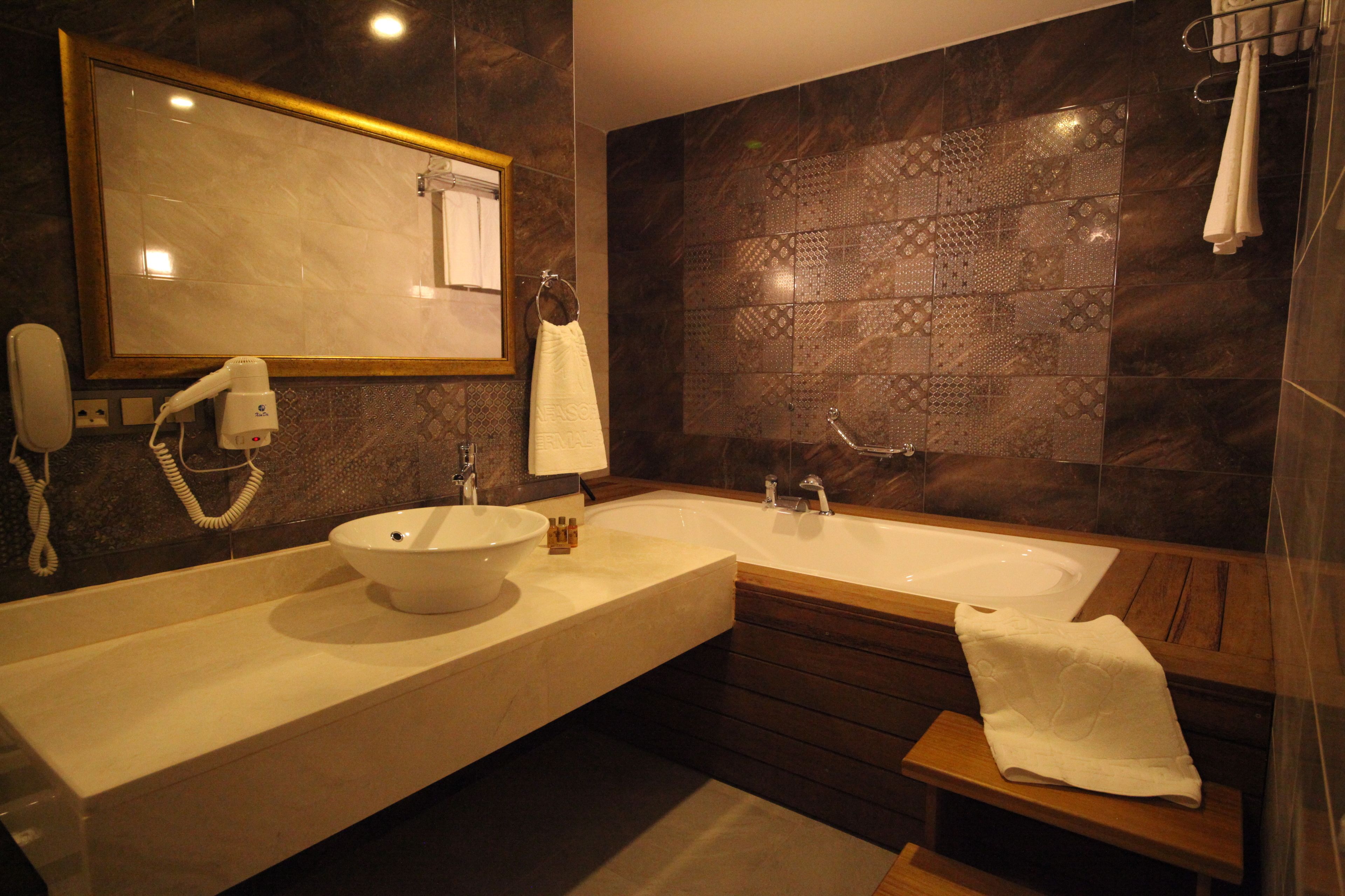 Un baño moderno con lavamanos doble, un espejo grande y un mueble de tocador de madera.