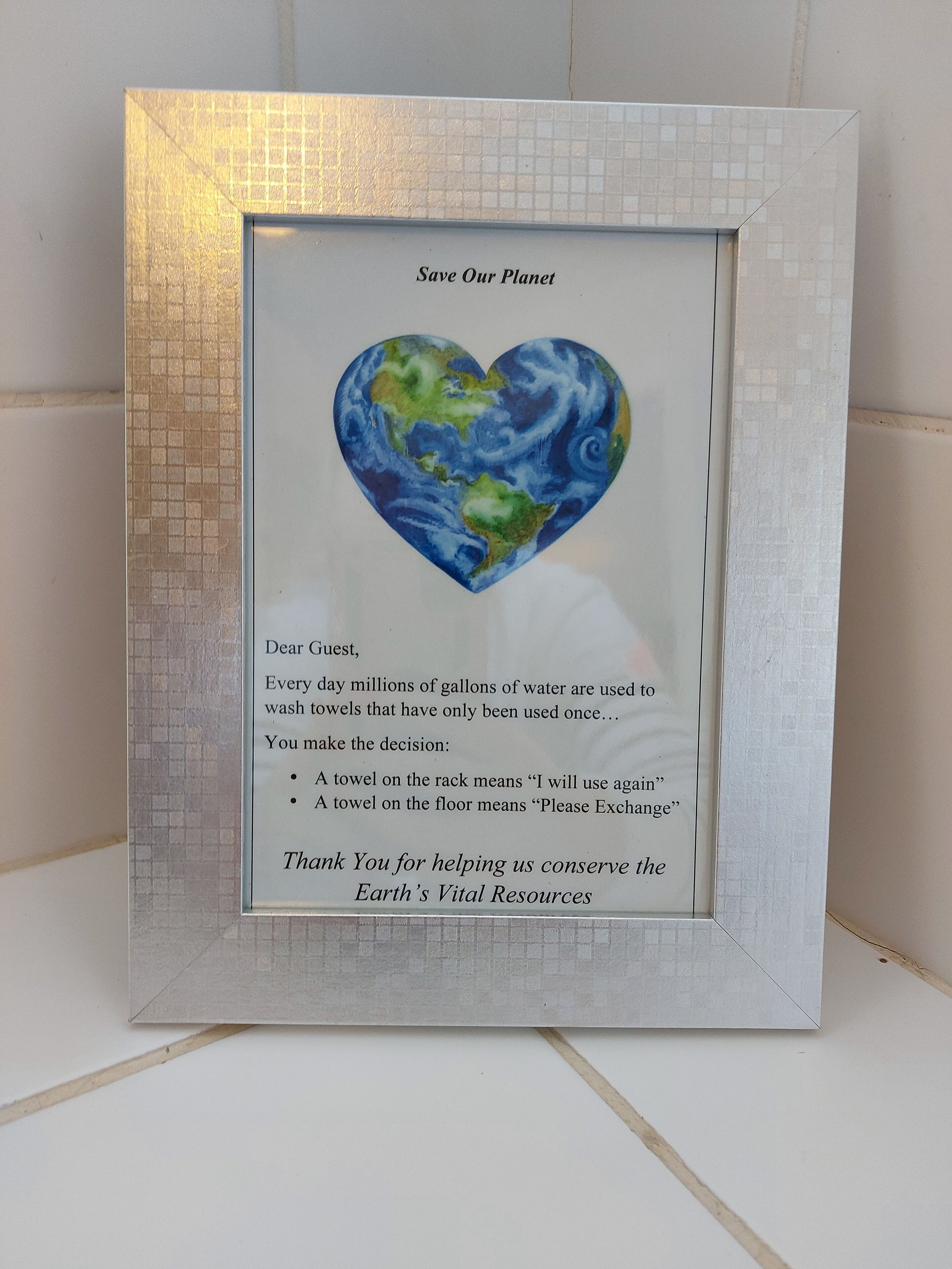 A framed message board with a heart-shaped Earth illustration and a conservation message.