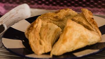 A plate with three triangular pastries on a checkered tablecloth.
