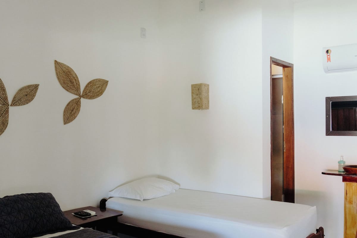 Un dormitorio con cama, mesita de noche y lámpara colgante.