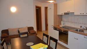 A compact kitchen with white cabinets, a built-in oven, and a sink. - Apartments Lake Bohinj (Bohinj)