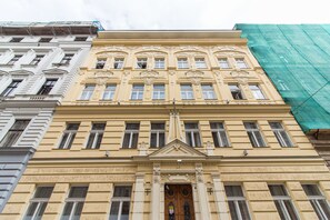A multi-story building with a classical architectural style, featuring ornate window frames and decorative elements around the entrance. - Melnicka Flat (Prague)