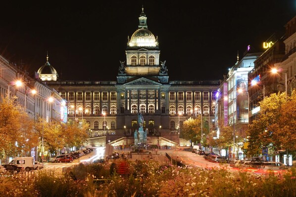 A large, illuminated building with a prominent dome and statues in front. - Melnicka Flat (Prague)