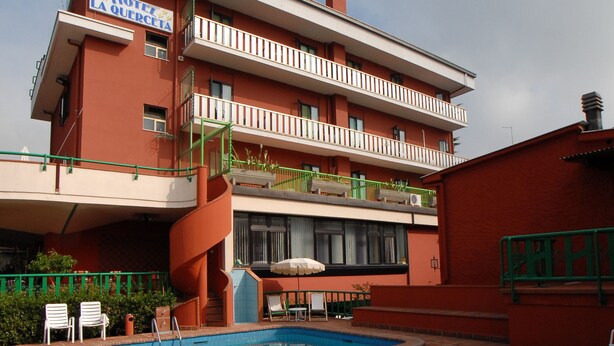 A hotel with a swimming pool, outdoor seating, and a red facade. - La Querceta (Montecatini Terme)
