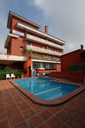 A hotel with a swimming pool, outdoor seating, and a red facade. - La Querceta (Montecatini Terme)