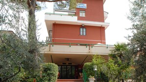 A building with a red facade, a balcony, and a sign that reads "HOTEL DE LA OLECETA". - La Querceta (Montecatini Terme)