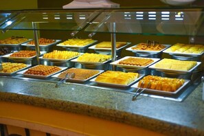 Un bufé con diversos platos dispuestos en fuentes.